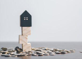 Holzhaus und Münzen